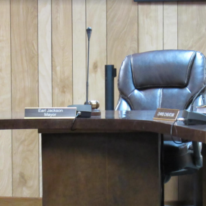 Name plate for Mayor Earl Jackson on desk with empty chair behind it