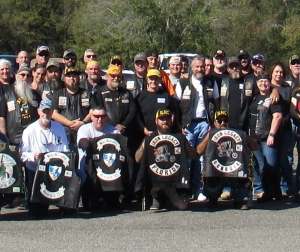 A large group of bikers, friends, and family gather to honor Terry Arnold